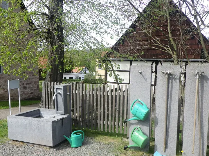 Punkt poboru wody z konewkami na cmentarzu